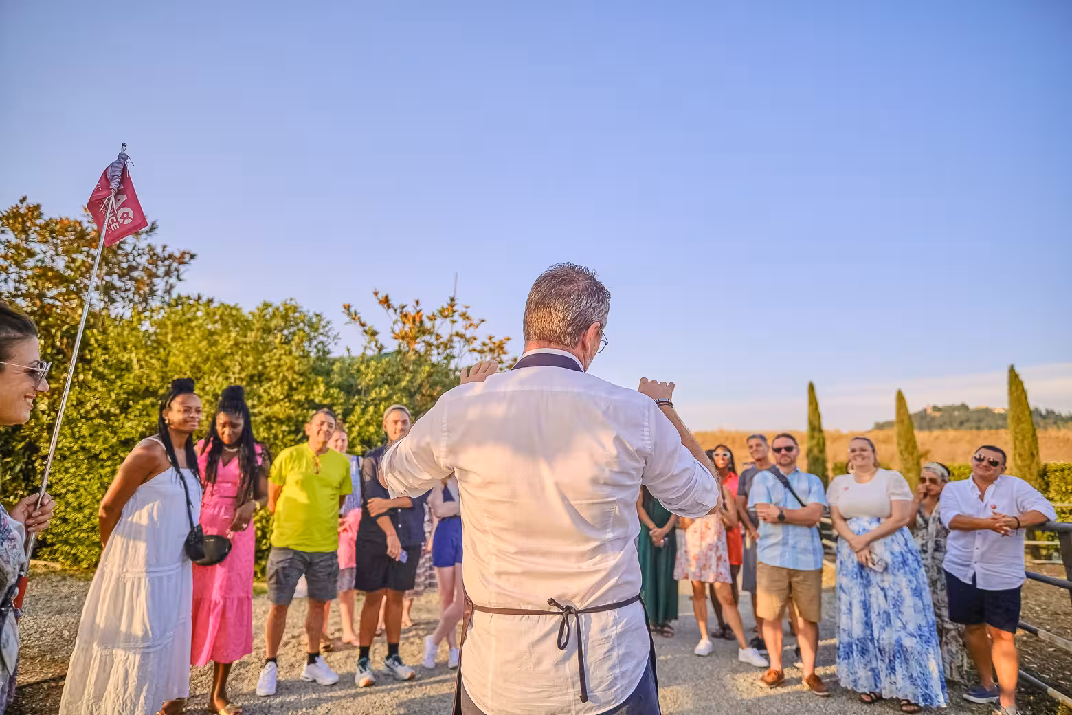 Tour guide leads an engaged group through Chianti's vineyards, highlighting the winery's unique features.