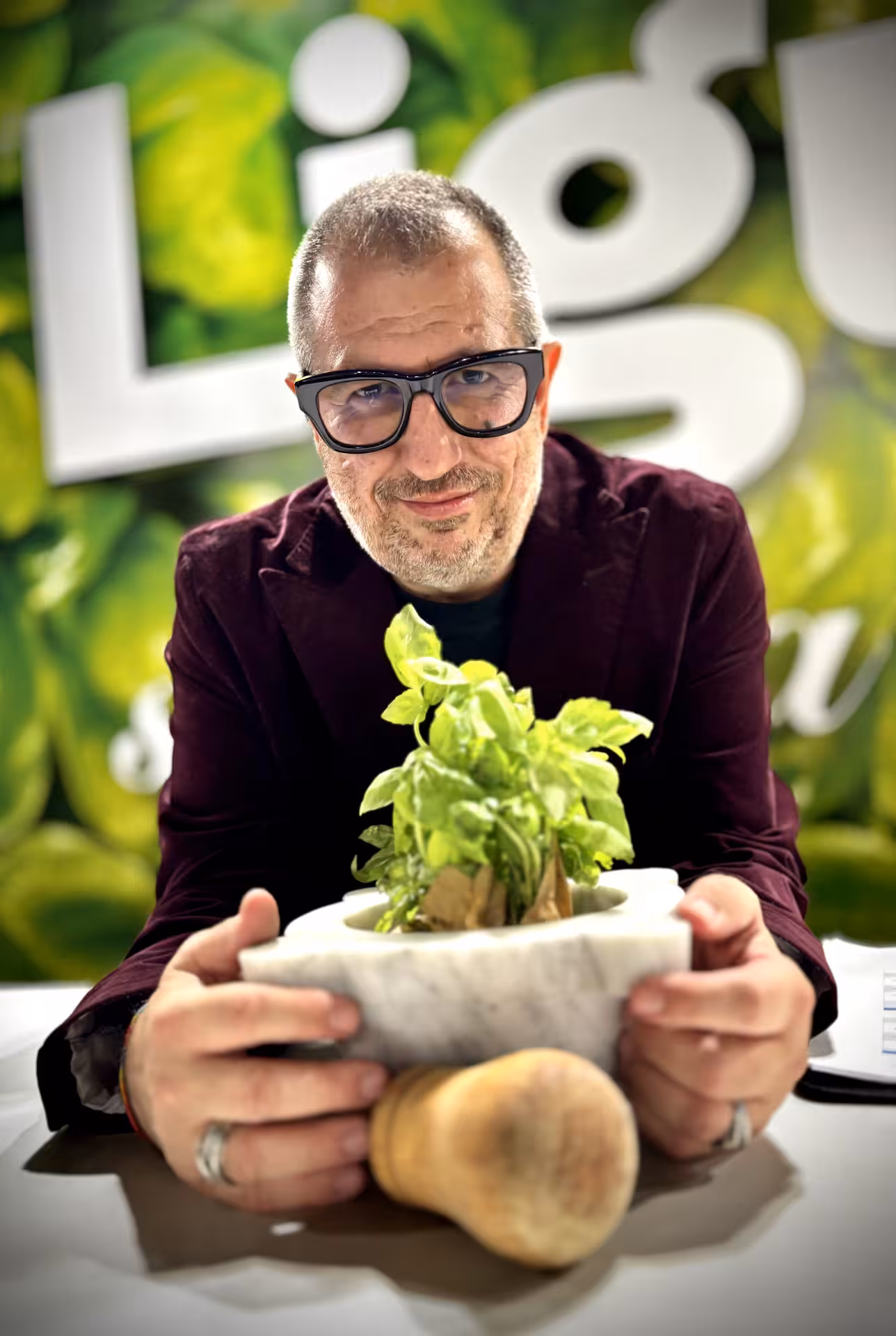 Man showcasing fresh basil in a marble mortar, highlighting Italian culinary traditions in Chiavari food tour.