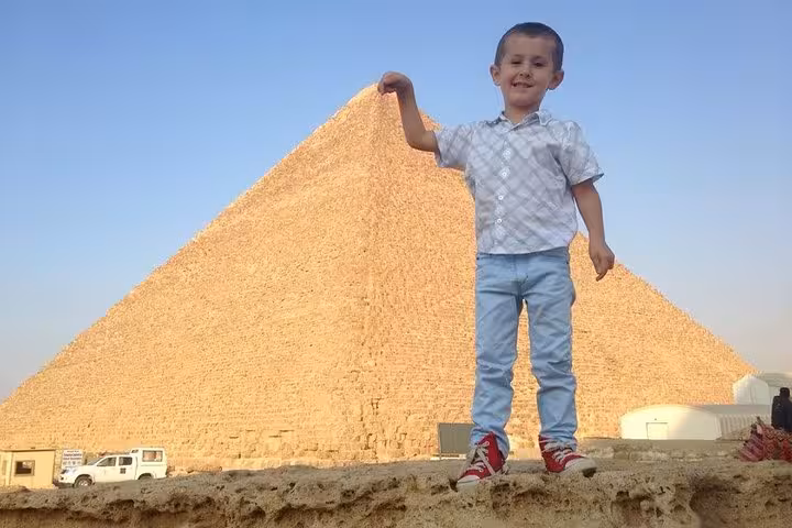 Child posing at the Giza Pyramid during a private Cairo day trip from Makadi Bay, Soma Bay, and El Gouna