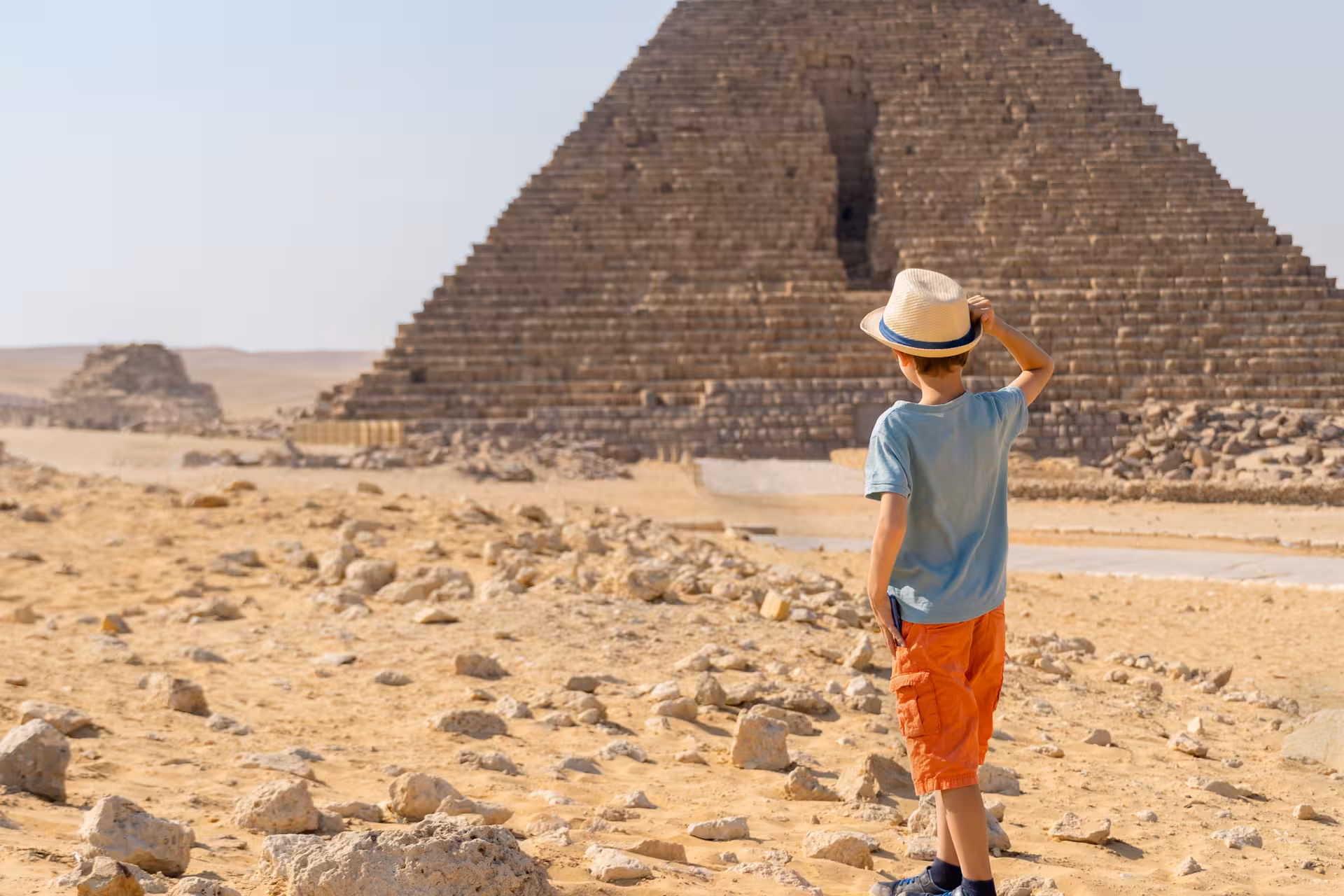 Child looking at a Giza pyramid on a private Cairo day tour, family-friendly stop paired with Grand Egyptian Museum visit