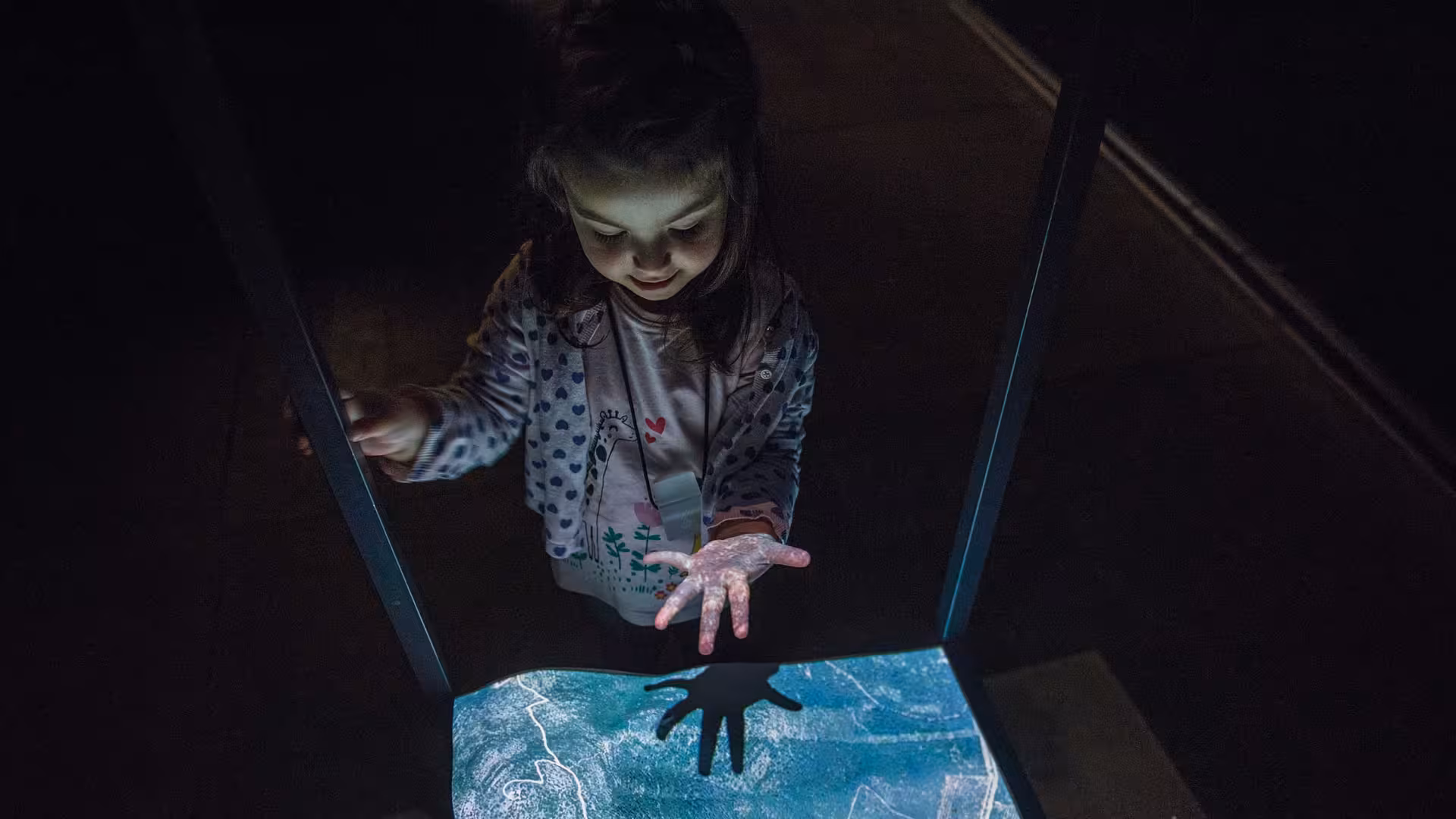 Child interacts with a hands-on exhibit at Alghero's Porto Conte Park Ecomuseum, highlighting family-friendly activities.