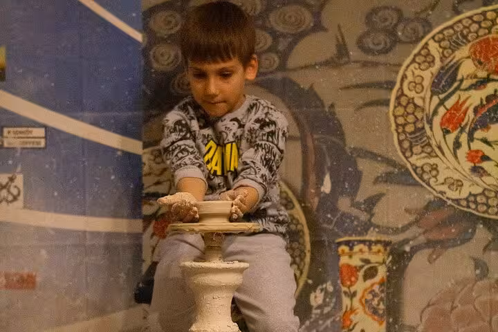 Child making pottery on a clay wheel in Kusadasi, fun hands-on stop on kids Ephesus shore excursion