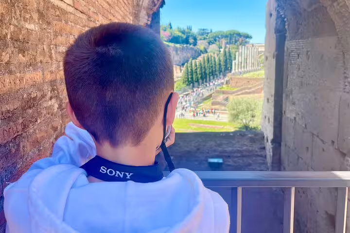 Child with camera overlooking Roman Forum ruins on an engaging kids friendly private guided tour of ancient Rome highlights