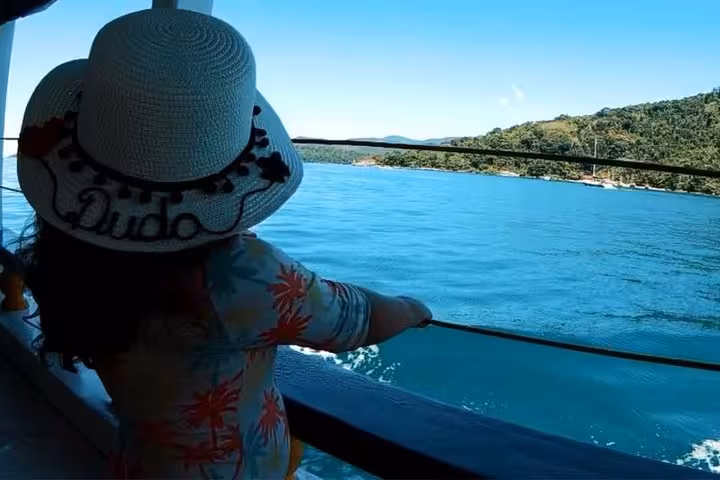 Child enjoying a scenic boat tour with clear blue waters and lush island views, perfect for family adventures.