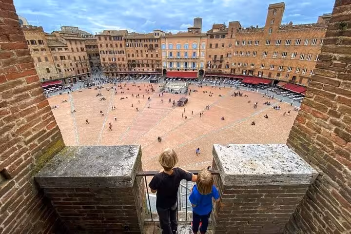 Children overlooking the bustling Piazza del Campo in Siena, Italy, capturing the lively atmosphere and historic architecture.