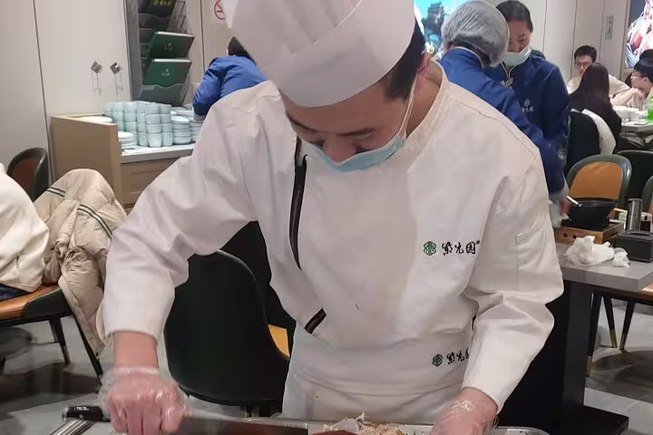 Chef expertly preparing roast duck at a restaurant on the 14-day China and Yangtze River cruise tour.