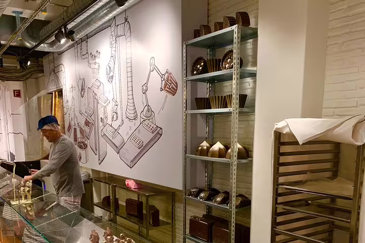 Chocolate artisan at work in a shop with industrial decor on the Bern Small Group Tour featuring chocolate tasting.