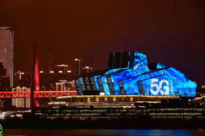 Chongqing cityscape at night with futuristic architecture and vibrant 5G light displays for cyberpunk city tour.