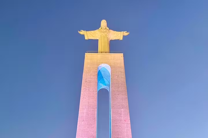 Statue of Christ the King illuminated against a clear blue sky, a highlight on the Setúbal & Arrábida Wine Tour from Lisbon.