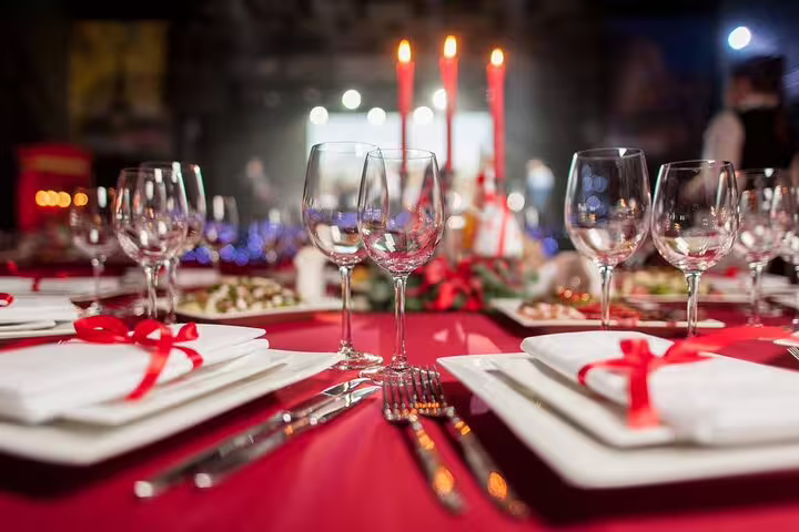 Elegant Christmas dinner table setting with candles and festive decorations for river cruise with DJ.