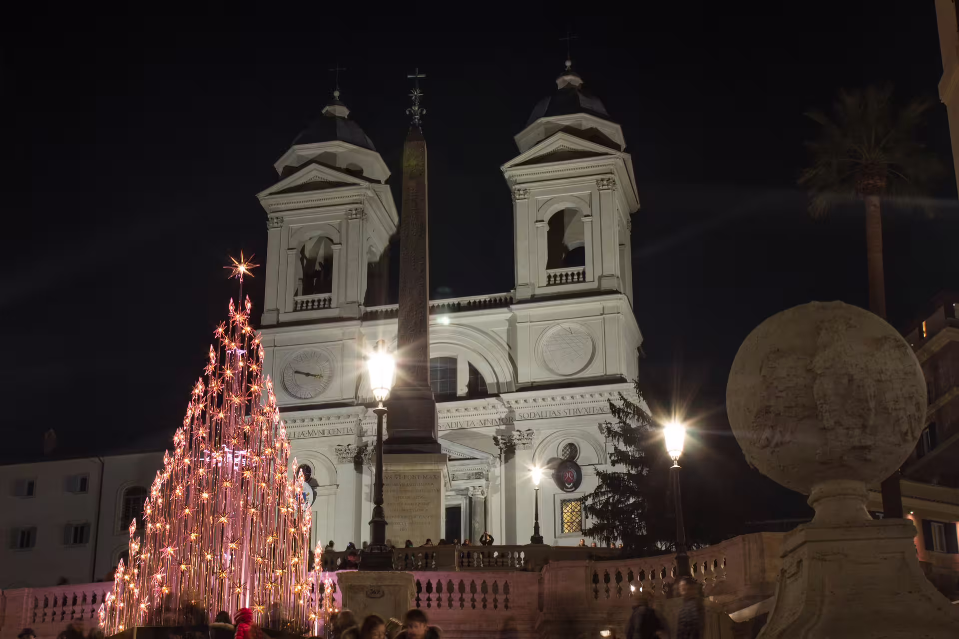 Illuminated Christmas tree and church at the Spanish Steps in Rome, captured on a night-time Christmas walking tour