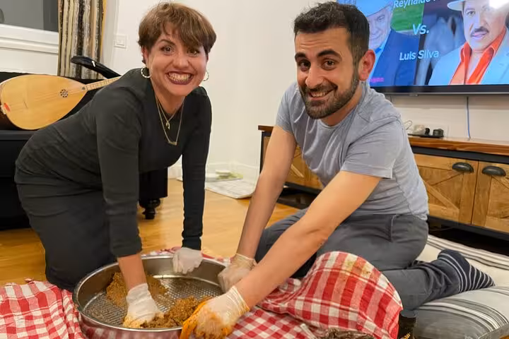 Guests knead spicy çiğ köfte in a home cooking class, preparing Turkish meze with traditional music night