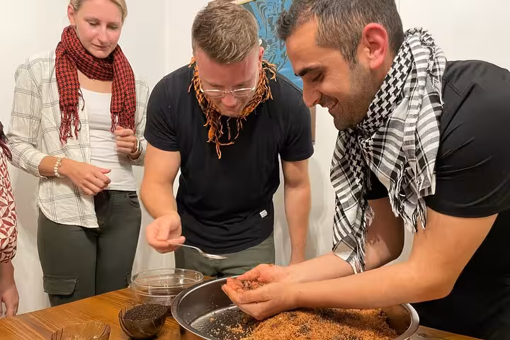Guests knead spicy çiğ köfte mixture in a home kitchen during Turkish cooking class with live traditional music