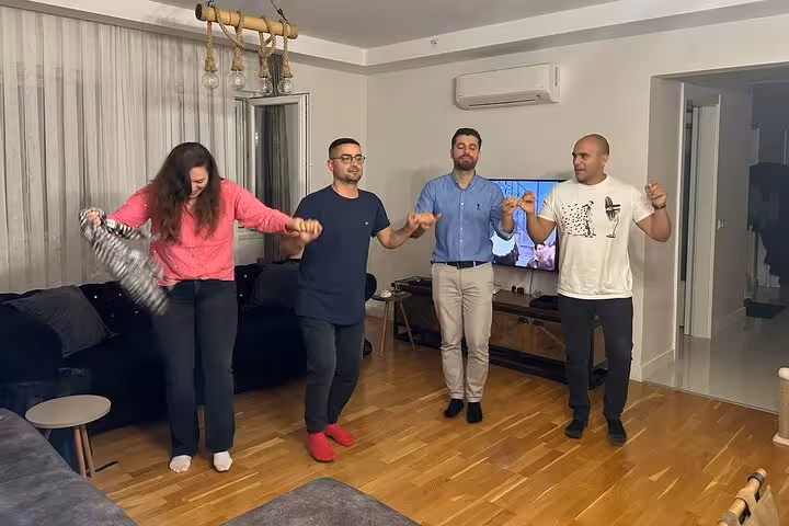 Guests join hands for Turkish folk dance at home during Çiğ Köfte cooking class and live music night
