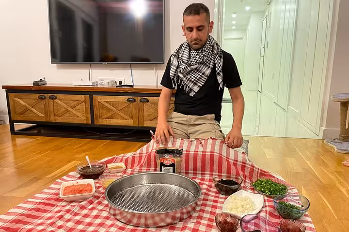 Host sets ingredients for çiğ köfte cooking class at home, part of a traditional Turkish music night