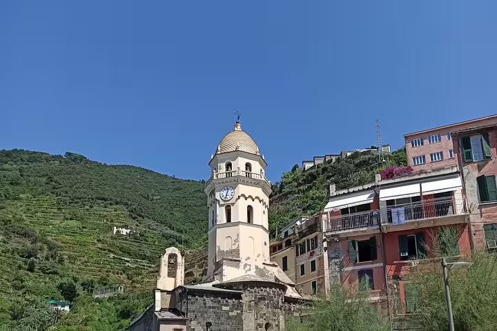 Historic church tower and colorful hillside houses in a sunlit Cinque Terre village on a private Portovenere day trip