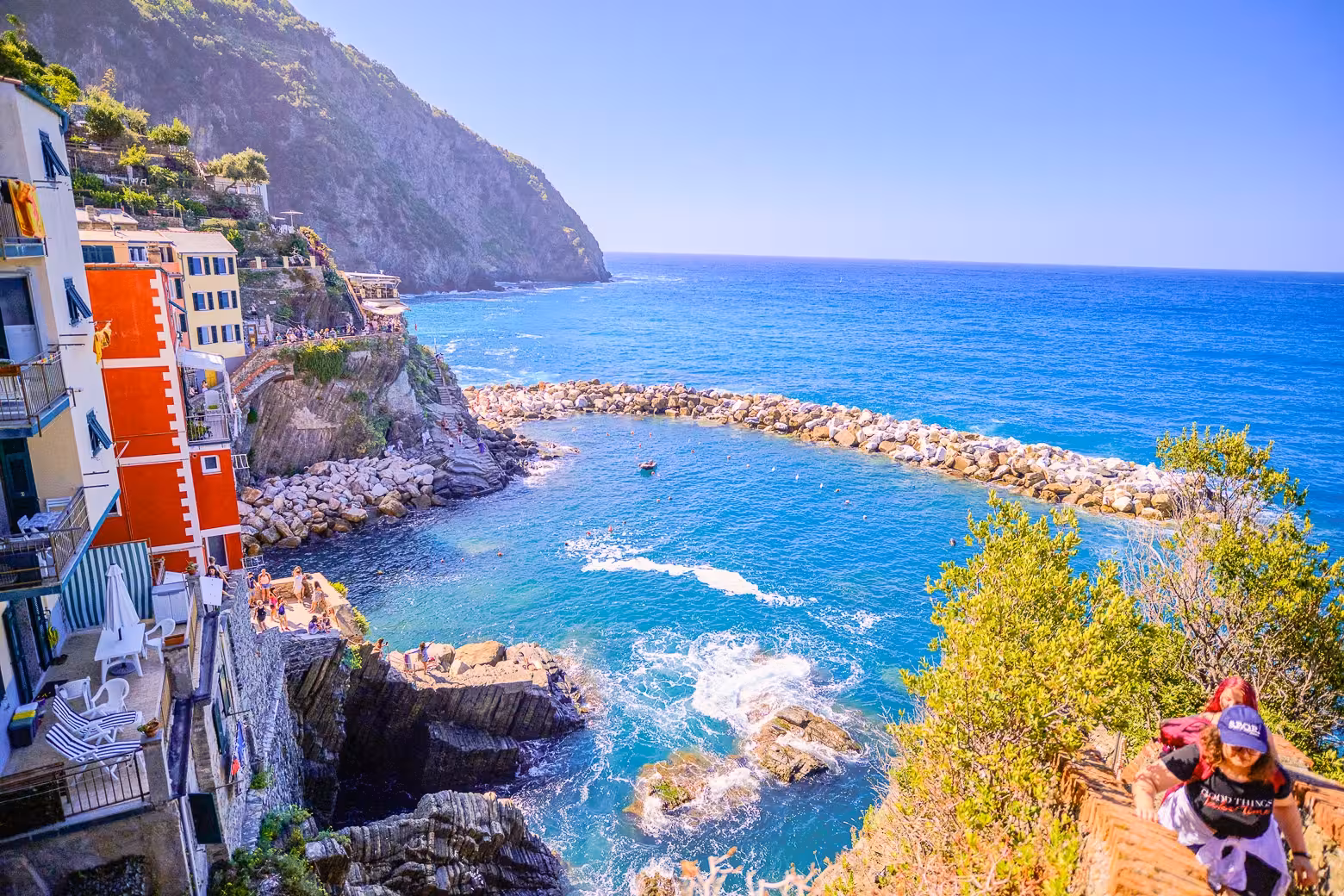 Scenic view of Cinque Terre coastline with colorful buildings and clear blue sea on a sunny day.