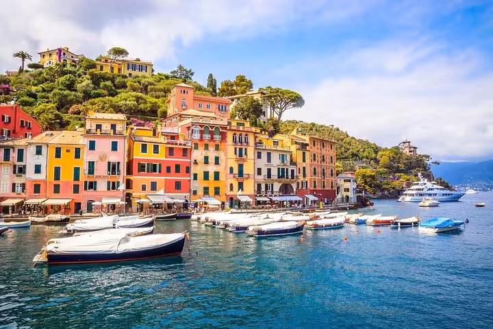Vibrant coastal view of Cinque Terre with colorful cliffside buildings and boats in the azure sea.