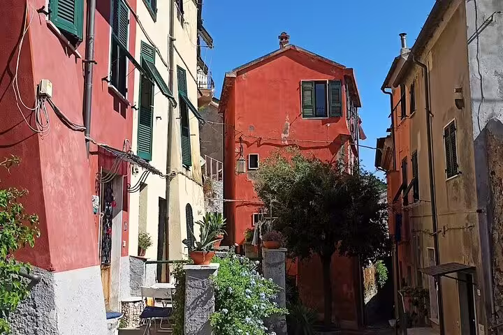 Narrow alley of colorful Cinque Terre houses with plants and blue sky on a La Spezia cruise transfer day trip
