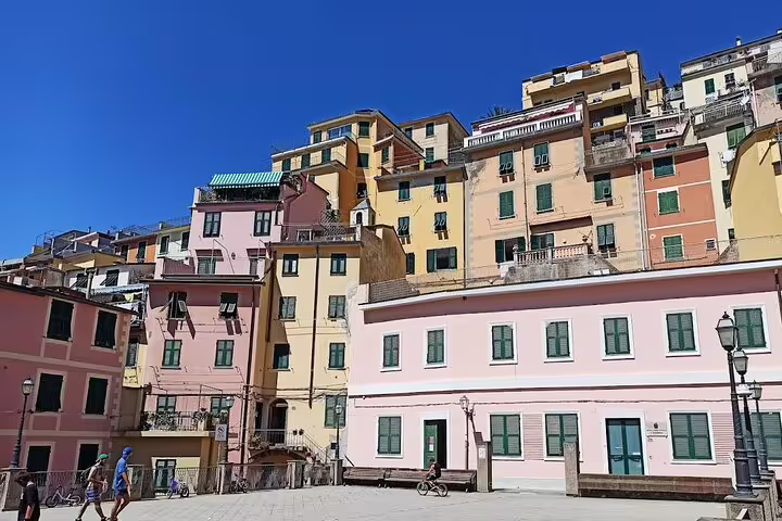 Colorful pastel houses in a sunny Cinque Terre village, seen on a shore excursion transfer from La Spezia cruise port