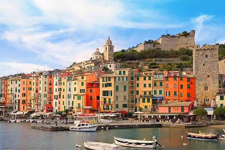 Vibrant seafront houses and boats in a Cinque Terre harbor, captured on transfer tour from La Spezia cruise ship