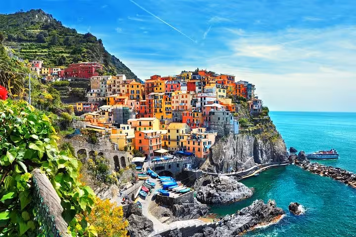 Picturesque view of Manarola's vibrant cliffside houses against the turquoise sea in Cinque Terre, Italy.