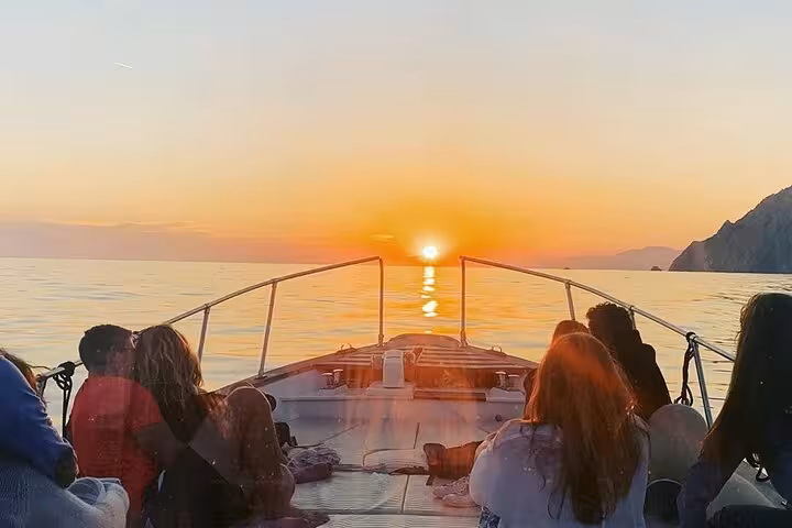 Tourists enjoy a mesmerizing sunset boat ride on the serene waters of Cinque Terre during a private day trip.