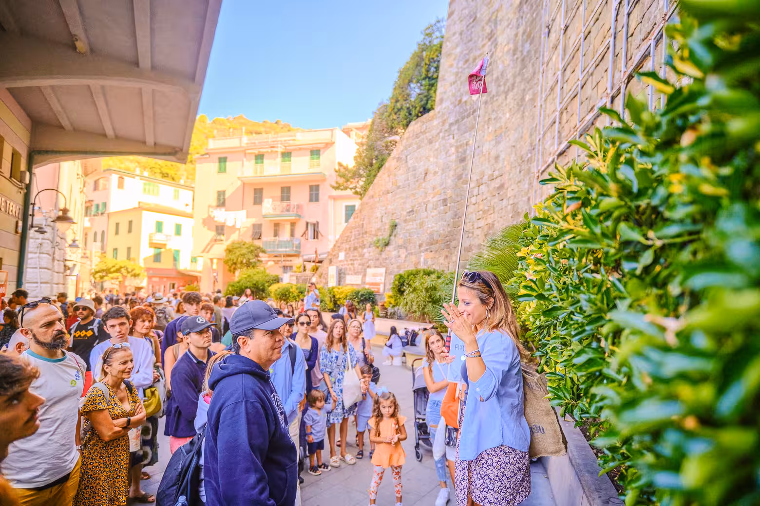 Tour guide leading a group in the vibrant streets of Cinque Terre, highlighting cultural exploration on a day trip.