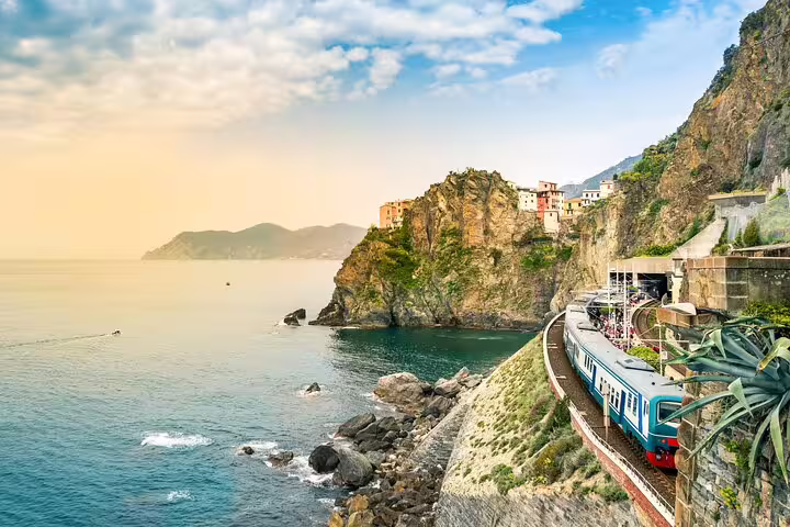 Scenic train from La Spezia curving along Cinque Terre’s rugged coastline with cliffside villages and Ligurian Sea views