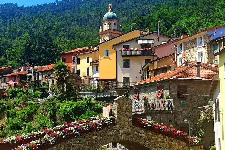 Colorful hillside village near La Spezia with church tower and stone bridge, seen on Cinque Terre cruise transfer excursion