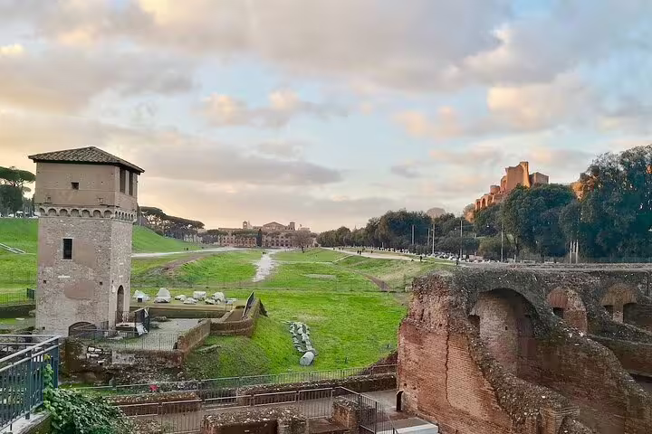 Ancient ruins and green racing track of Circus Maximus at sunset on a private chauffeured sightseeing tour in Rome