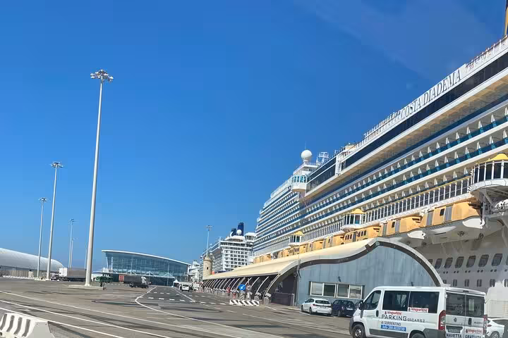 Cruise ships docked at Civitavecchia Port under a clear blue sky, showcasing the starting point for transfers to Rome.