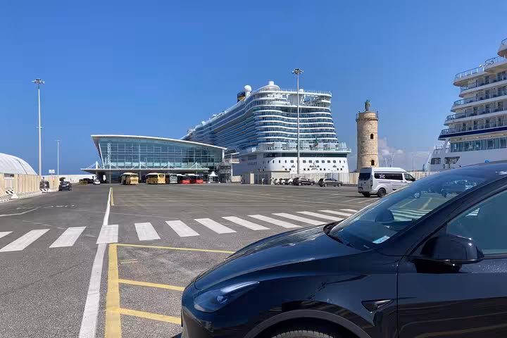 Cruise ship docked at Civitavecchia Port, gateway for private day trips to Rome, with modern vehicles ready for transfer.