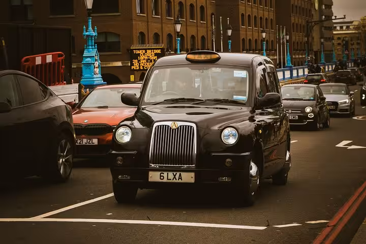 Black classic cab driving through busy city street, showcasing comfortable transport for the Premier Classic Muscat private tour