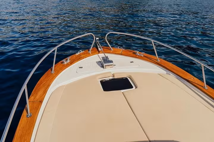 Elegant deck of Classic Gozzo boat showcasing teak details against calm waters, designed for a luxurious Sorrento tour.