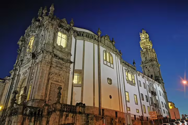 Historic Clerigos Church illuminated at night in Porto, featured on a two-day private tour from Lisbon, Portugal.