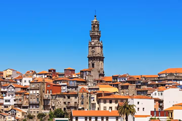 Clérigos Tower rising above Porto's skyline under a clear blue sky, seen on a private tour from Lisbon.