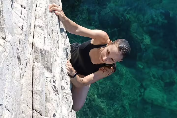 Close-up of climber on limestone cliff above turquoise sea on Split deep water solo adventure tour