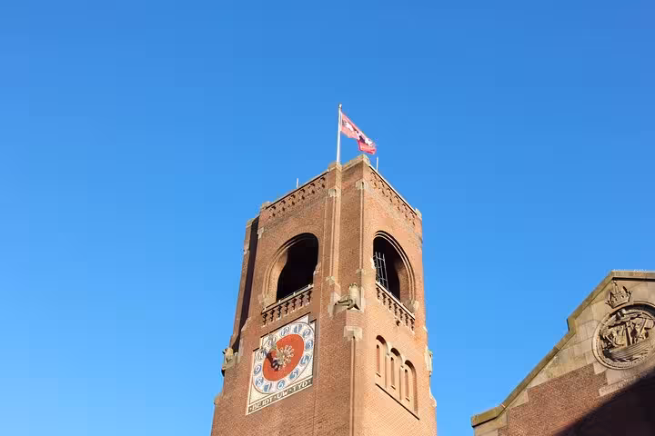 Clock tower with Dutch flag against blue sky, a landmark stop on a private city walking tour with a local
