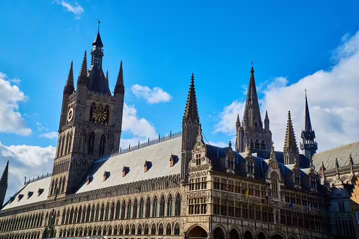 Cloth Hall and Belfry in Ypres under blue sky, landmark stop on the self-guided e-scavenger hunt tour