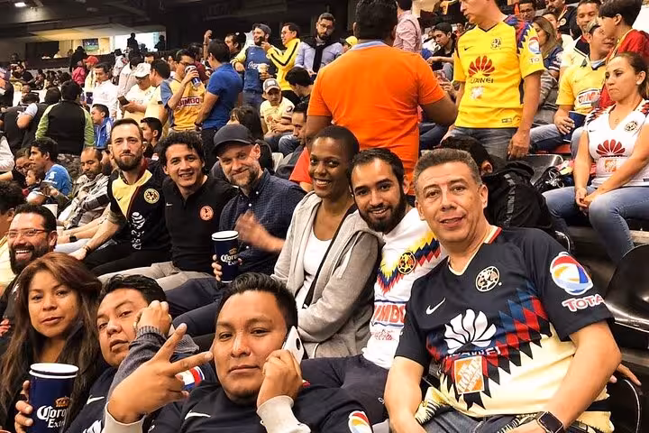 Fans in Club América jerseys sitting together at Mexico City match, local soccer matchday experience