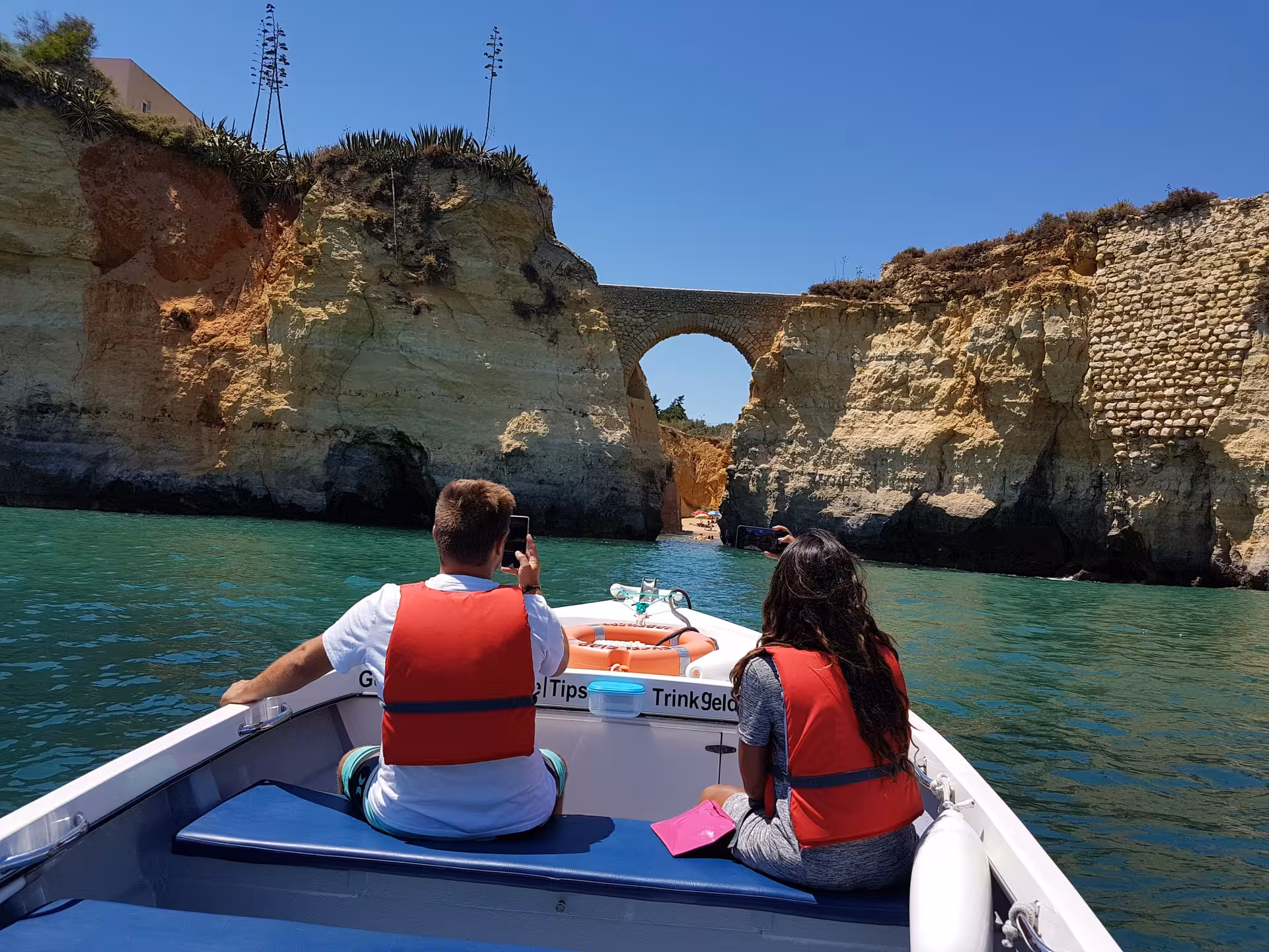 Small group on a coastal boat trip in Lagos sailing toward the stone arch cliffs of Ponta da Piedade in the Algarve