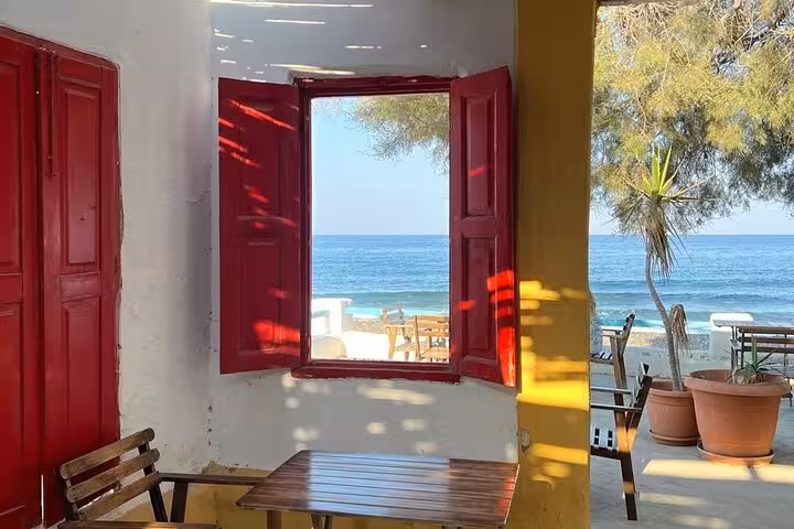 Coastal winery terrace with open red shutters and sea view, stop on private sunset wine tour with tapas