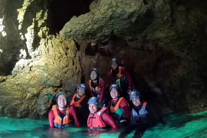 Group of coasteering adventurers smiling in a cave during a full-day Lisbon outdoor adventure tour.