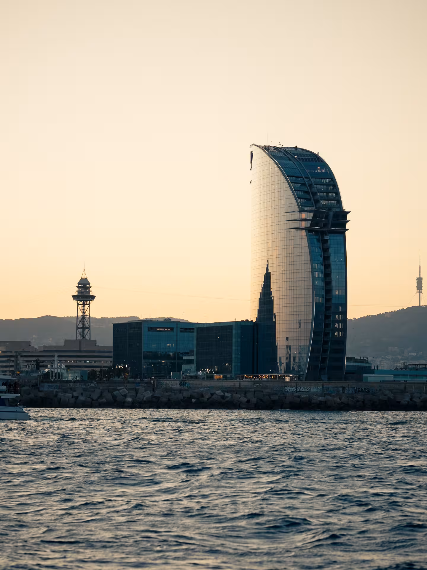 Sunset waterfront skyline near a modern glass tower, perfect pre-drinks vibe for a cocktail masterclass