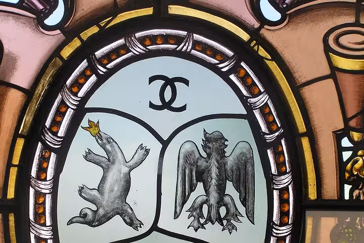 Stained glass window with iconic symbols, hinting at Coco Chanel's influence on the Cannes tour.