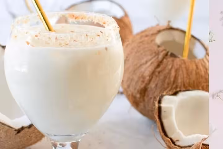 A creamy coconut cocktail with fresh coconuts, perfect for enjoying at sunset on Ipanema Beach.