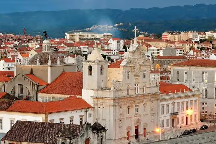 Panoramic view of Coimbra's historic architecture at dusk, highlighting a stop on the Lisbon to Porto transfer tour.