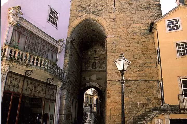 Historic Coimbra archway and narrow street, highlighting medieval architecture on a private walking tour.