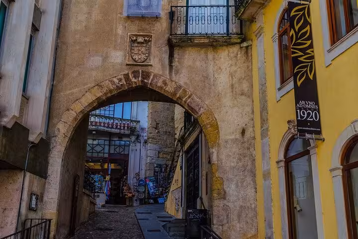 Explore Coimbra's historic archway on a private walking tour, showcasing medieval architecture and charming streets.